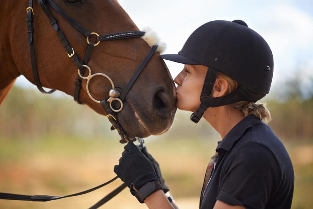 The Trainers Loft second hand equestrian gear, A young female rider being affectionate with her chestnut horse.