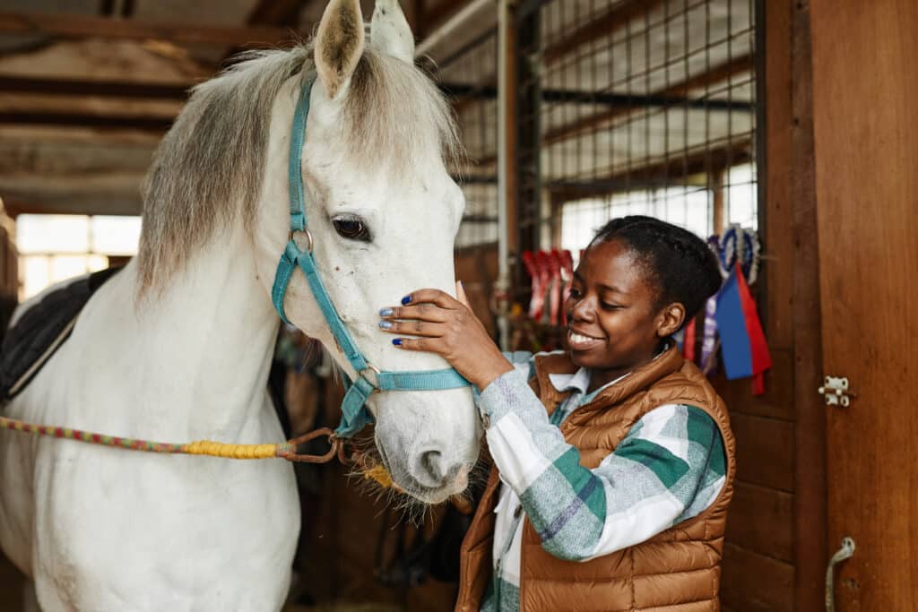 The Trainers Loft Horse Training Gear, Woman with White Horse in Stables