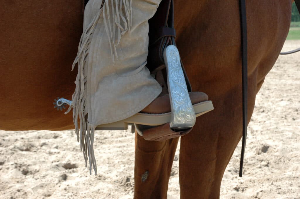 The Trainer's Loft Western Safety Stirrups, unidentified individual riding a horse with foot in stirrup